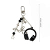 Silver metal music note charms hanging from a chain and a black hoop.