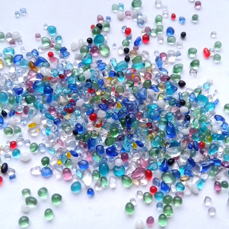 A scatter of colorful decorative stone pebbles including blues, greens, pinks, and whites.