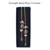 A silver chain necklace featuring pink lotus-shaped pendants on a dark blue background.