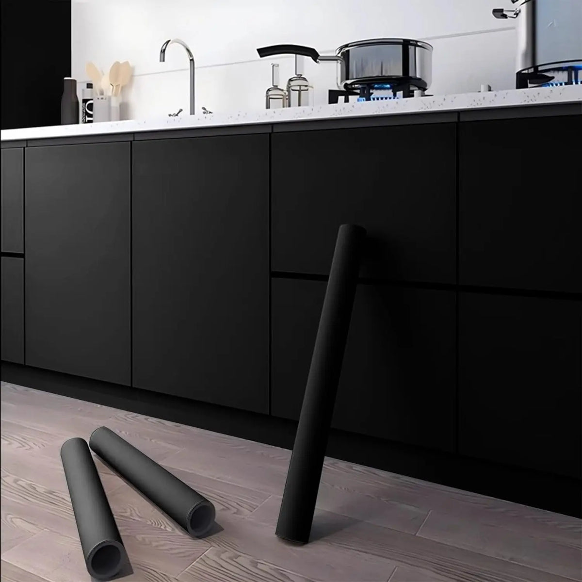 A roll of black self-adhesive peel-and-stick wallpaper lying on a wooden floor.