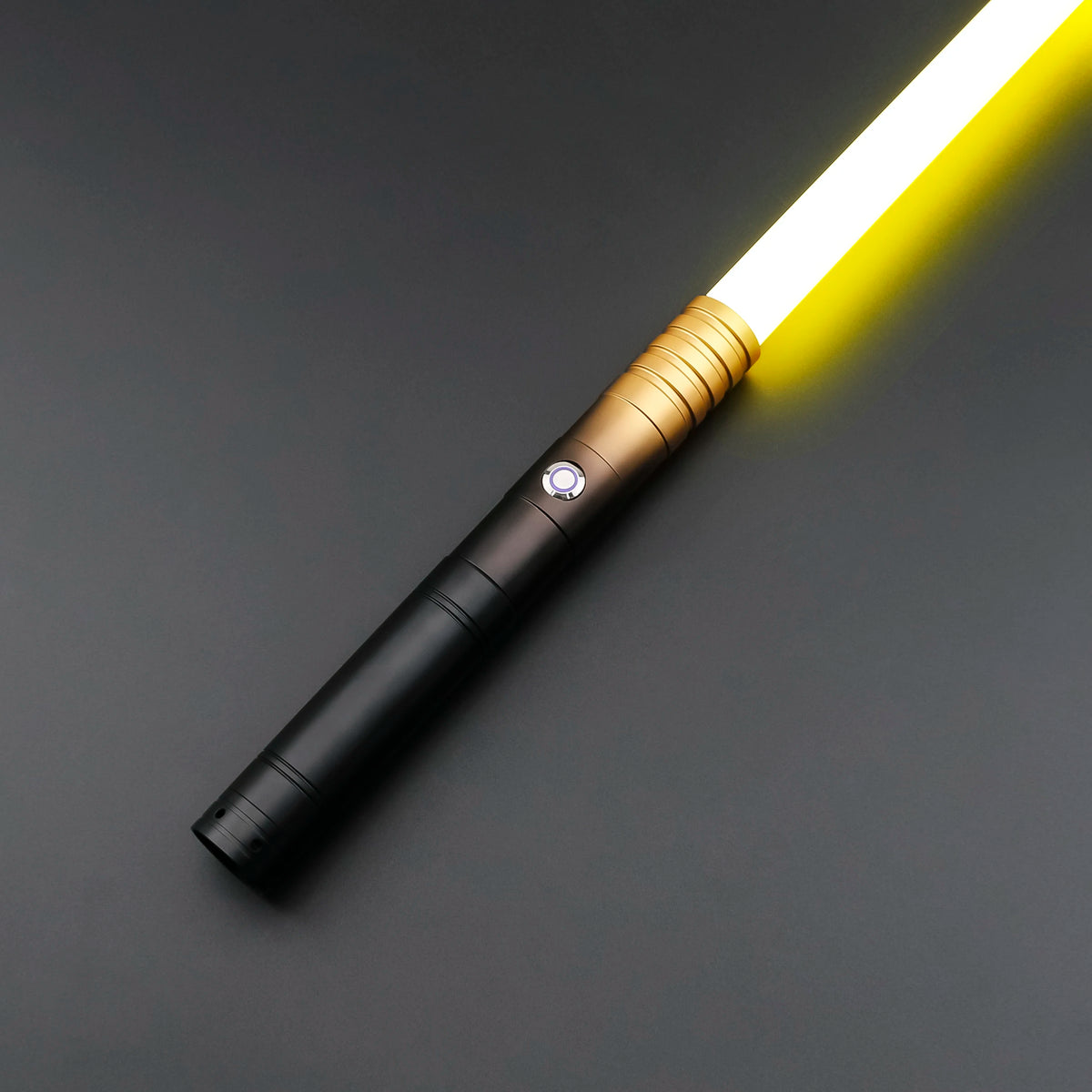 A close-up of an RGB heavy dueling lightsaber with a metal hilt and glowing yellow blade against a dark background.