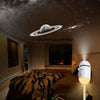A 2-in-1 mini galaxy star projector night light illuminates a room with a moon and stars projected onto the ceiling.