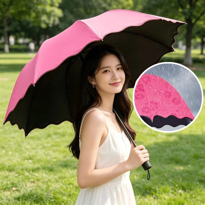 A woman holds a pink and black umbrella in a park setting with an inset showing the umbrella design.