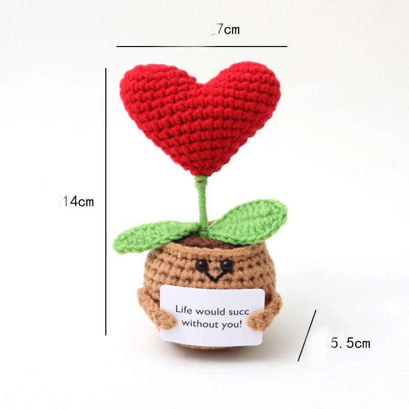 Handmade crochet positive energy doll shaped like a red heart with green leaves and a brown body.