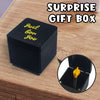 A black surprise gift box with gold lettering is shown next to a magnified view of the box's interior.