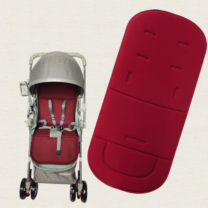 A silver baby stroller seat cushion is shown next to a red, padded seat cushion.