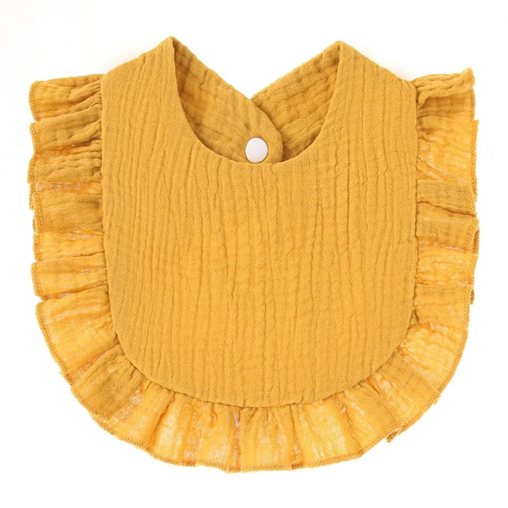 A mustard yellow, textured cotton baby bib in a bandana style with ruffled edges.