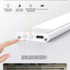 A hand presses a button on a white LED induction lamp to adjust the brightness level.