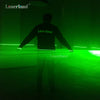 A person stands silhouetted against a bright green laser line, demonstrating the effect of a 532nm Green Laser Line Module.