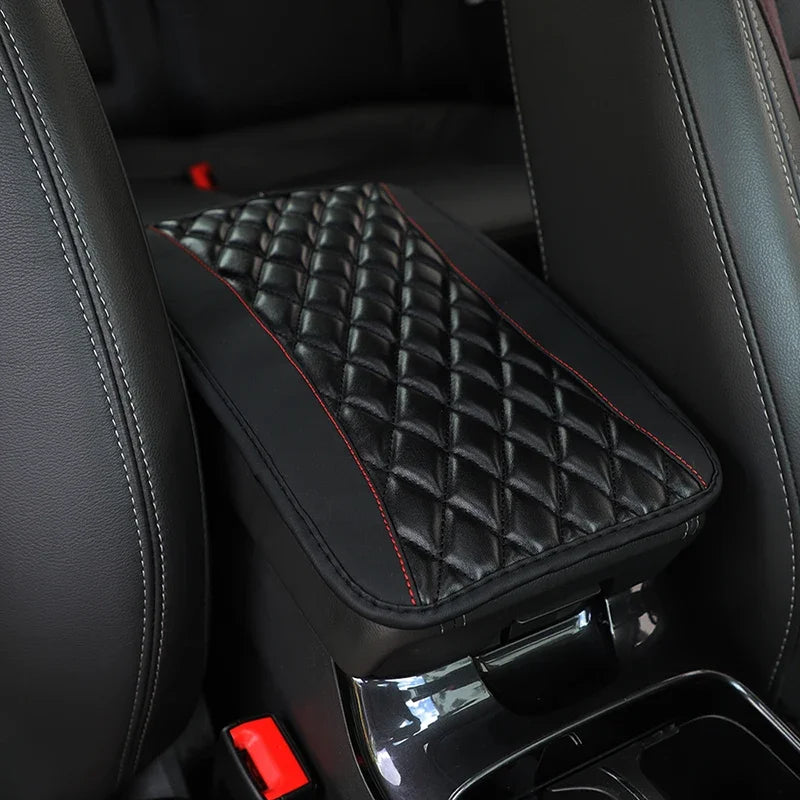 Black PU car armrest cover with a quilted storage pad and red stitching inside a vehicle interior.