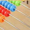 A wooden rainbow counting abacus with colorful beads strung on metal rods.