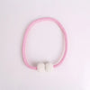 A pink beaded magnetic curtain tie-back clip bracelet with a pearl accent.