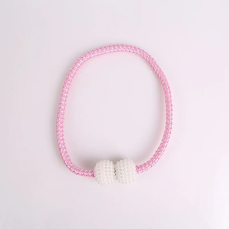 A pink beaded magnetic curtain tie-back clip bracelet with a pearl accent.