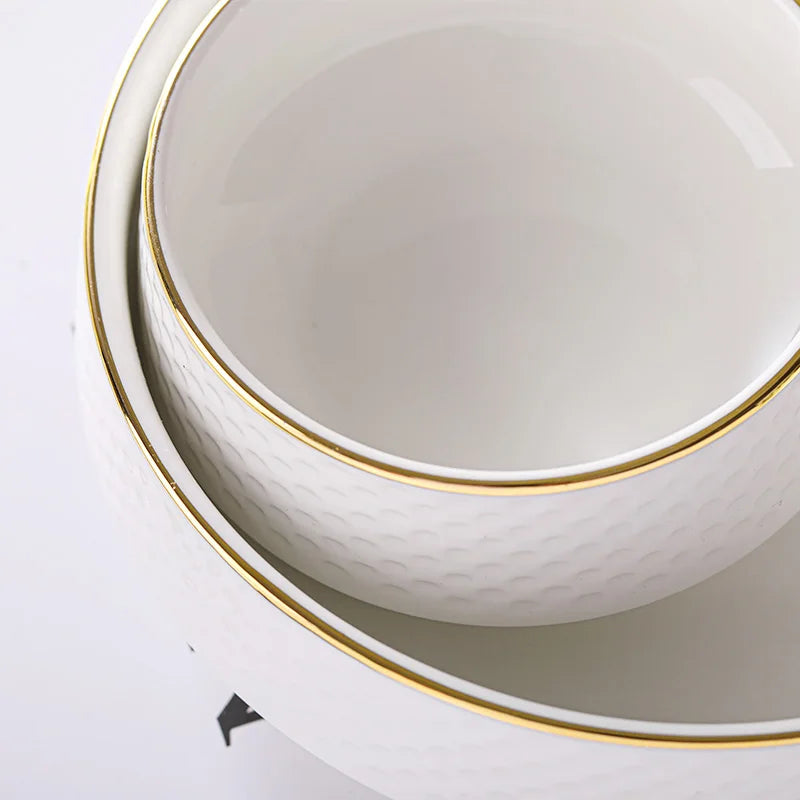 White porcelain soup bowl with gold trim and a textured surface.