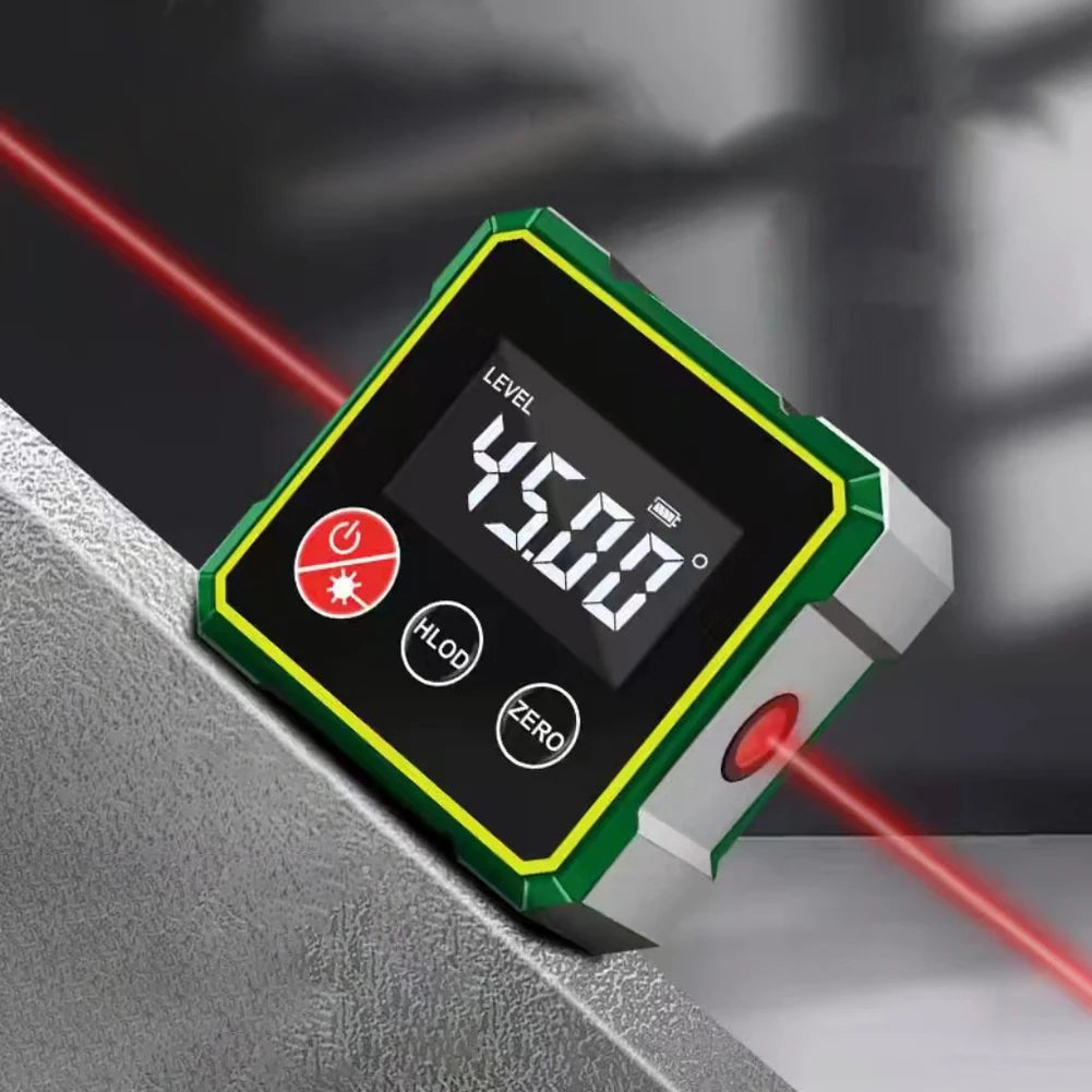 A digital angle finder device with a green and silver casing is shown resting on a gray surface, illuminated by red laser lin