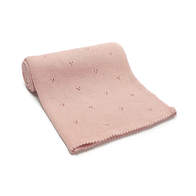A light pink, breathable knit cotton baby blanket with small embroidered dots.
