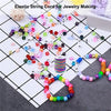 Assortment of colorful elastic string cords and beads for jewelry making arranged on a grid.