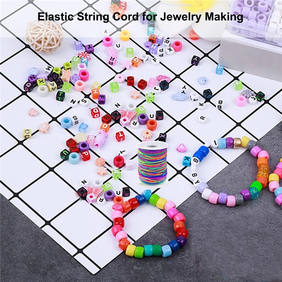 Assortment of colorful elastic string cords and beads for jewelry making arranged on a grid.
