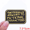 Black embroidered iron-on patch with yellow text that reads Emotionally Attached to Fictional Characters