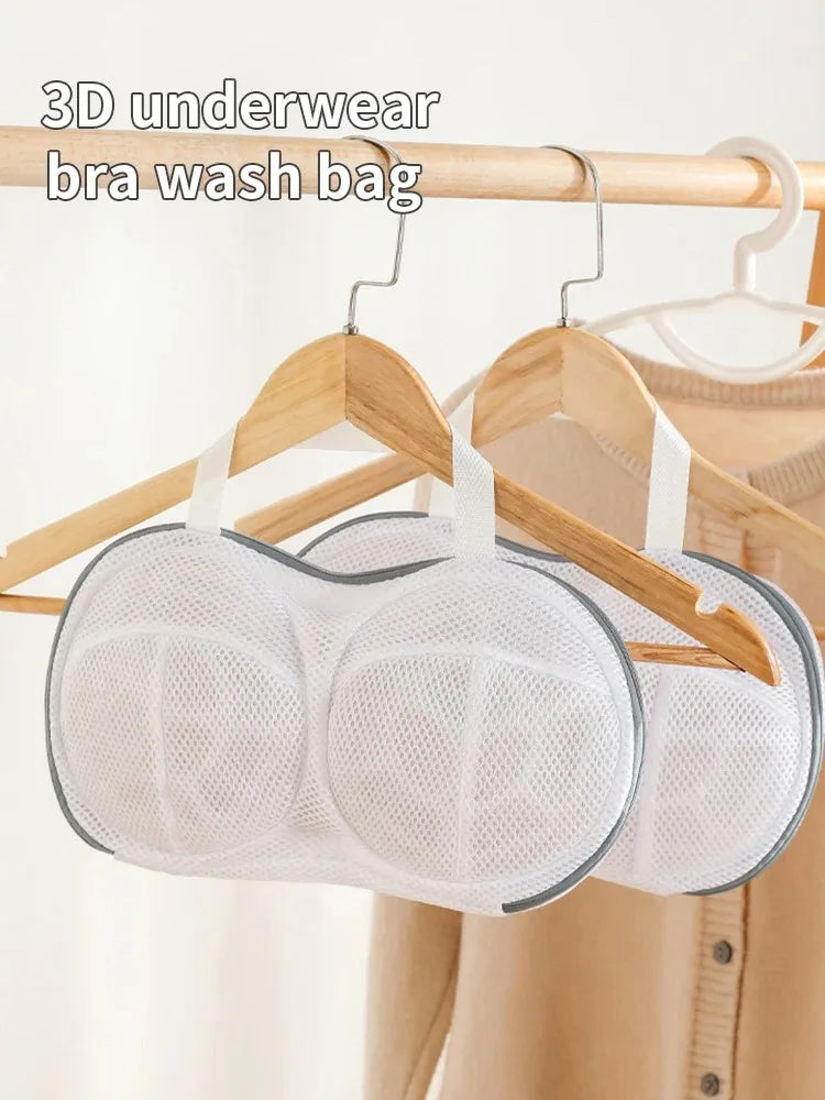 A white mesh bra wash bag is hanging on a wooden hanger.