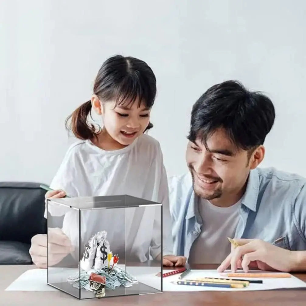 Un homme et une fille regardent une tirelire en acrylique sur une table avec des papiers.
