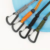 A collection of bungee tethers with carabiner hooks in gray, orange, black, and olive green colors laid on a blue surface.