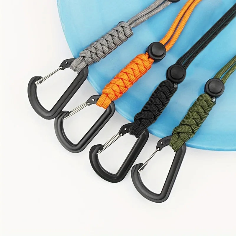 A collection of bungee tethers with carabiner hooks in gray, orange, black, and olive green colors laid on a blue surface.