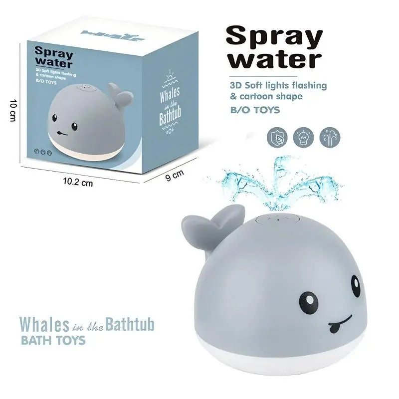 A gray light-up whale bath toy is shown next to its packaging box, demonstrating its features.