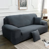 A dark gray silky soft stretchable sofa cover for pet owners displayed on a light rug.