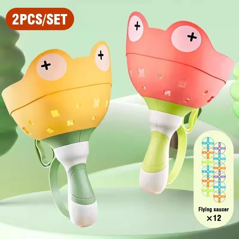 Two pink and yellow flying saucer toys for kids shown against a light green background.