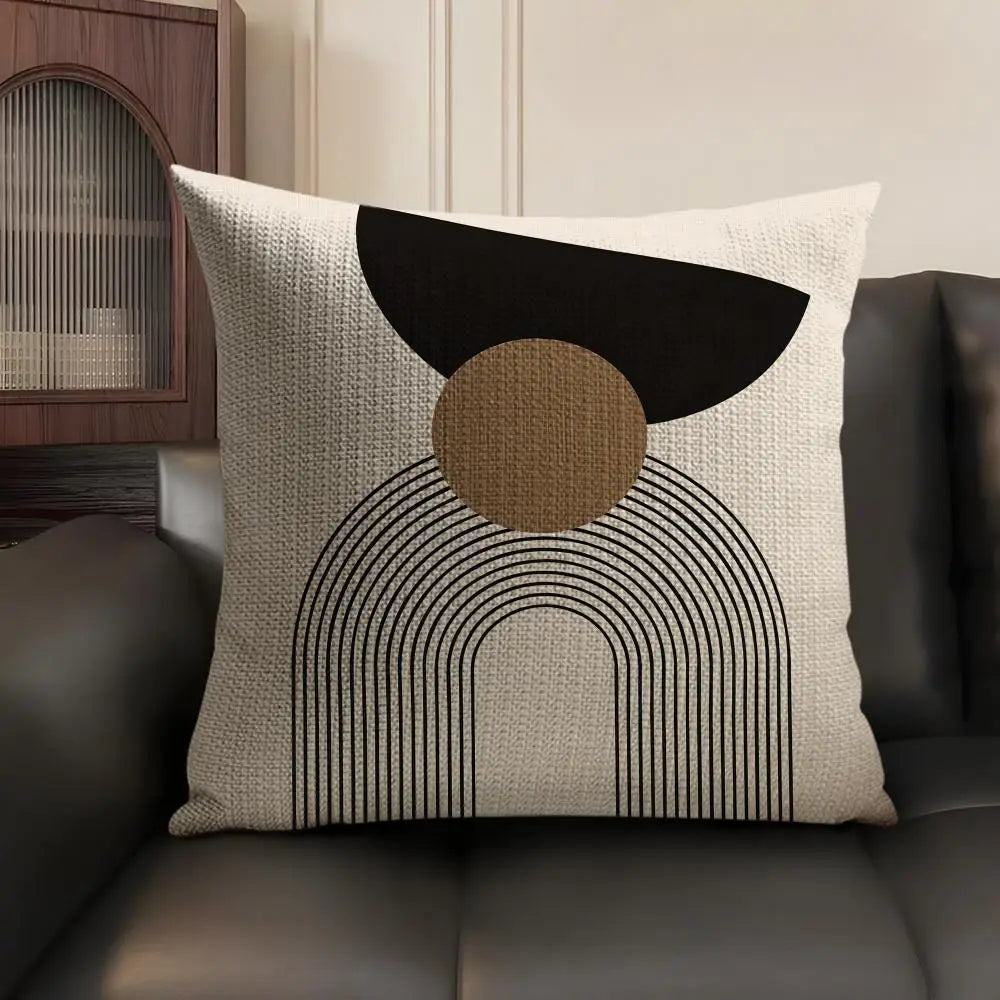 A beige linen cushion cover featuring a geometric design with black and tan shapes.