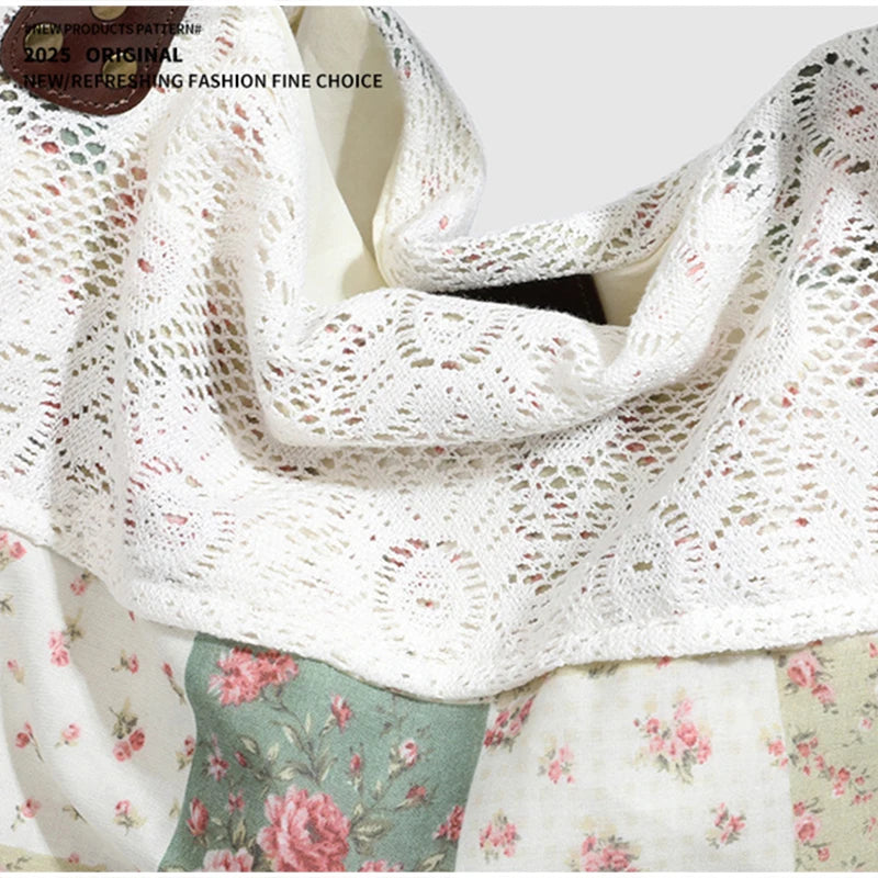Gros plan d'une écharpe en dentelle crochetée blanche avec des accents floraux roses, drapée sur un tissu patchwork.