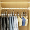 A row of gray and blue fabric hangers suspended from a stainless steel bar in a light wood cabinet.