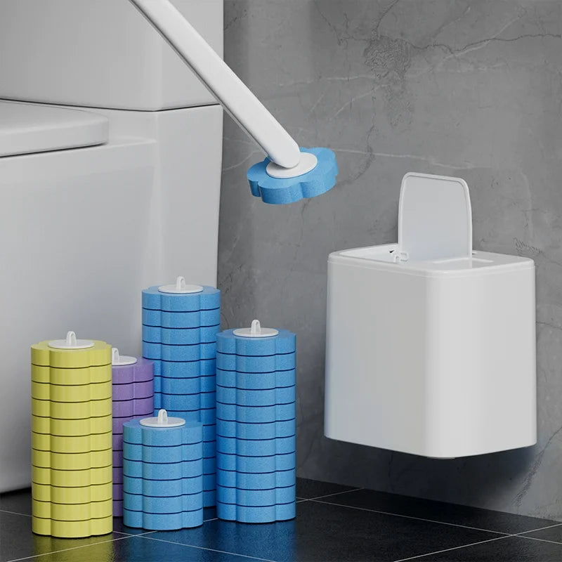 A white toilet cleaning brush kit with blue and yellow cylindrical brushes and an auto-open lid mounted on a gray wall.