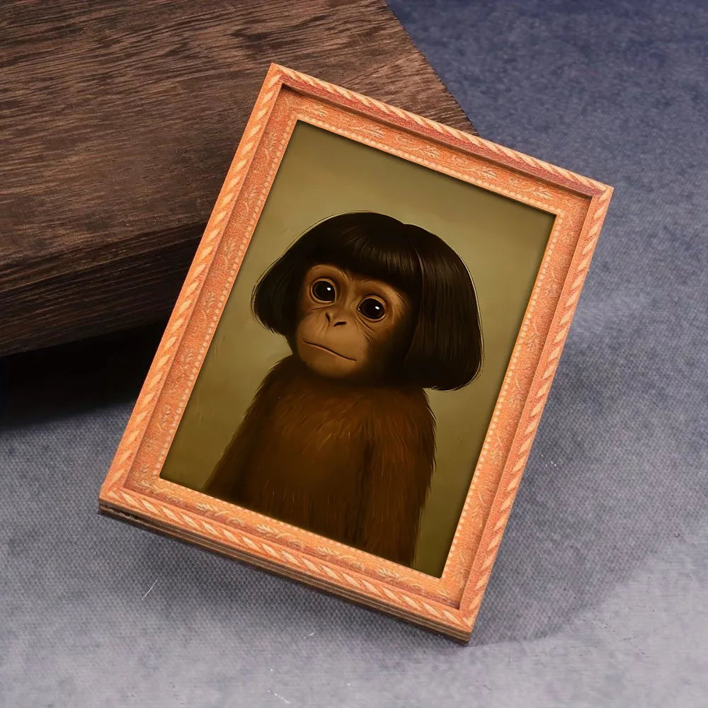 A framed picture of a monkey's face in a wooden frame resting on a blue cloth.