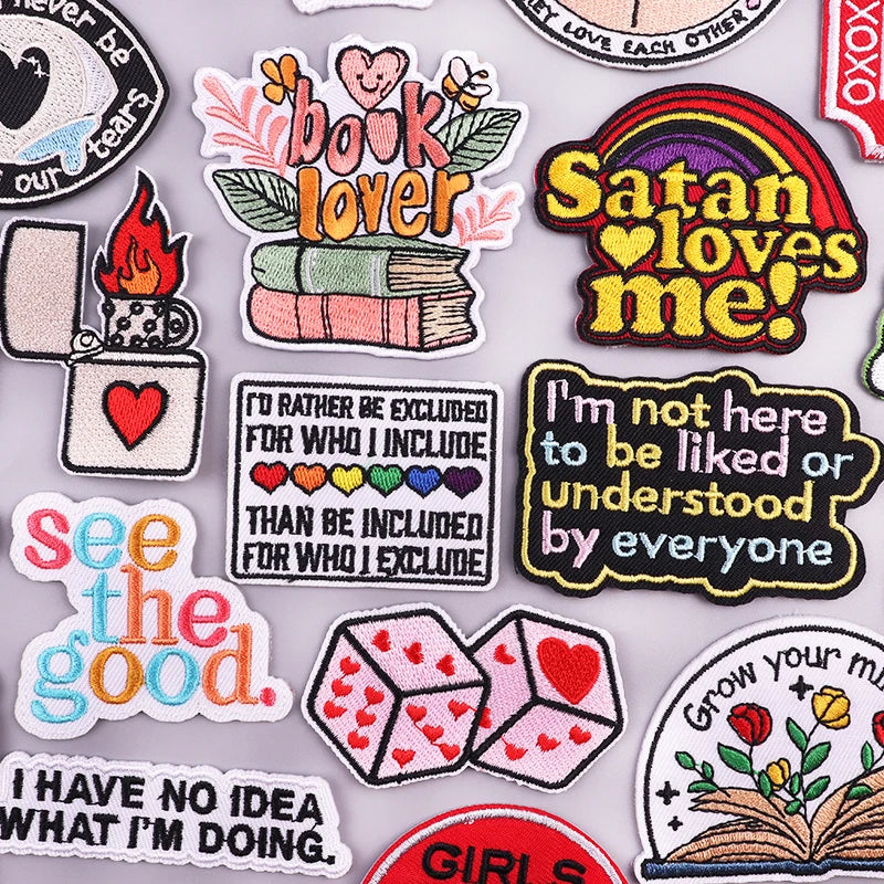 A collection of embroidered iron-on patches featuring various phrases and designs like book lover Satan loves me and see the 