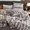 A fluffy gray faux fur bedding set featuring multiple pillows and a duvet on a bed.