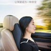 A woman is seated in a car, resting her head on a beige memory foam seat headrest pillow.