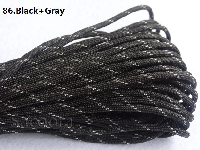 A bundle of black and gray 7-strand paracord rope is shown coiled on a white surface.