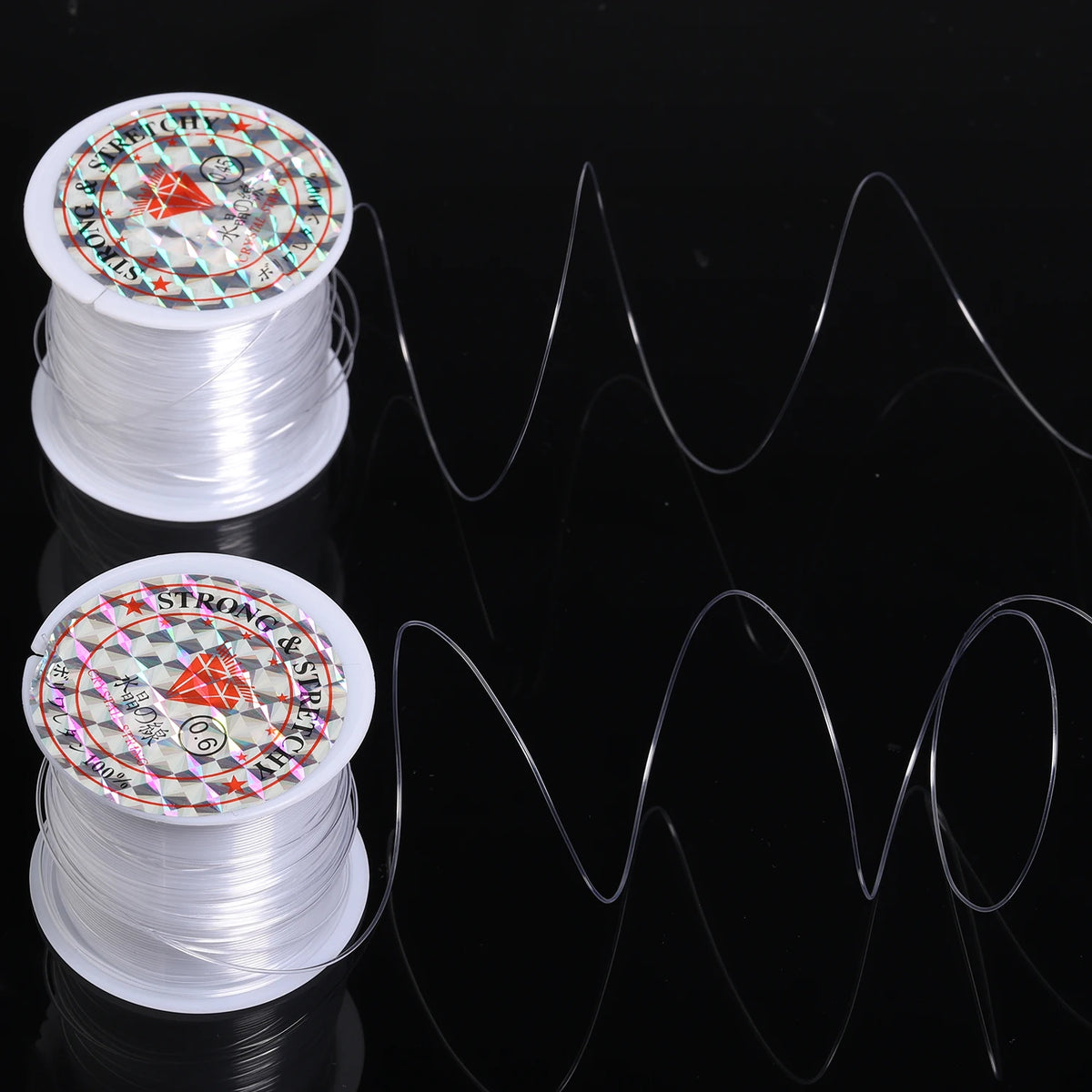 Two spools of white nylon beading cord for jewelry making with decorative labels