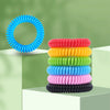 A stack of ten colorful silicone bracelets in various colors, including blue, red, yellow, green, cyan, pink, and black.
