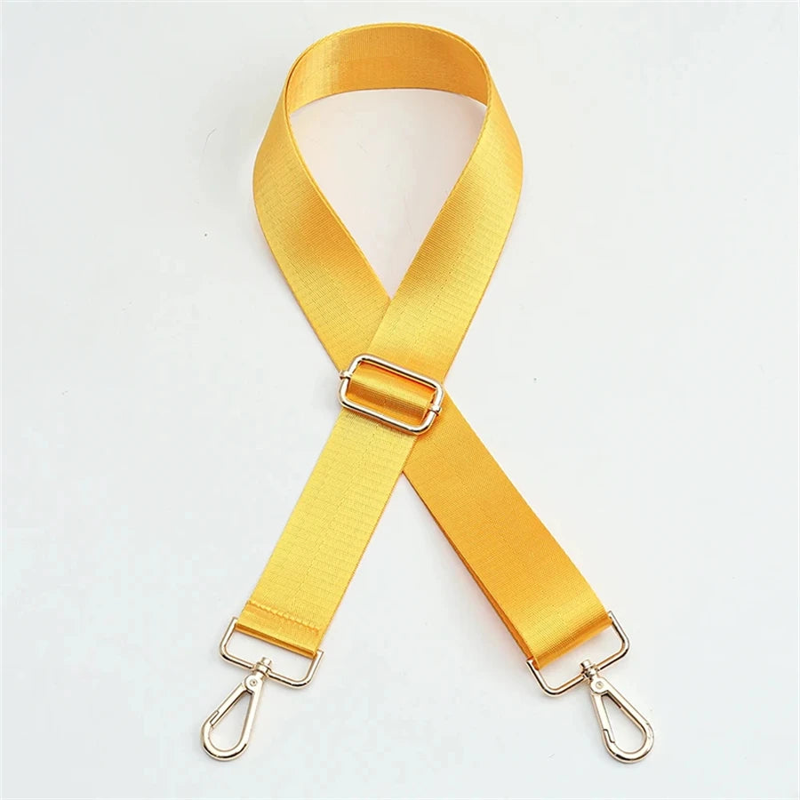 A bright yellow adjustable nylon bag strap with a gold buckle.