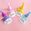 A set of pink, yellow, and blue felt birthday party hats and bibs for pets