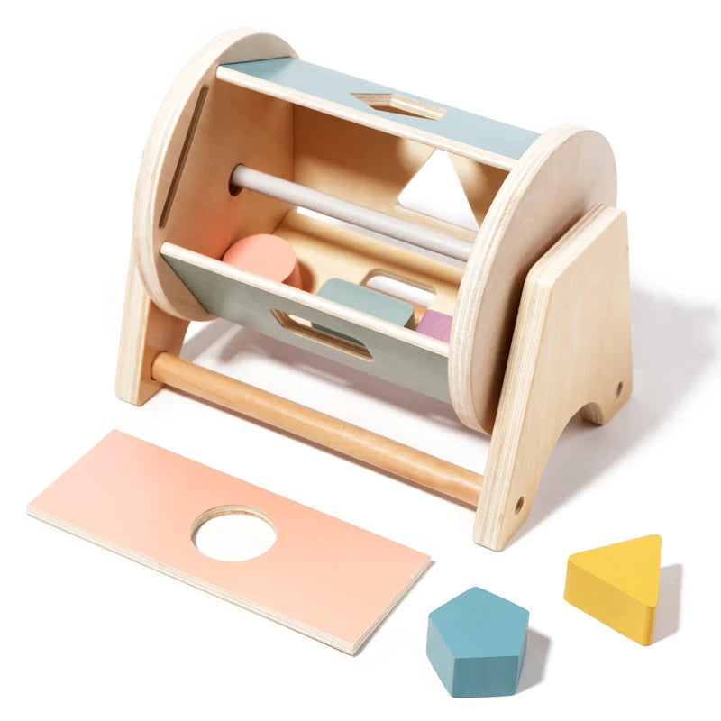 A wooden baby rattle bell with a soothing ring and various colored components is shown on a light wood background.