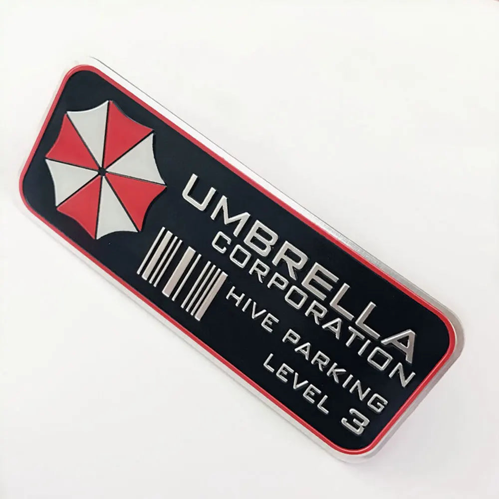 A black and red rectangular sticker with a white honeycomb design and the text UMBRELLA CORPORATION HIVE PARKING LEVEL 3