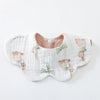 A white cotton baby feeding bib with a subtle floral pattern featuring small bear illustrations.