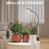 A small indoor plant is illuminated by a flexible gooseneck LED grow light, demonstrating its size and reach.