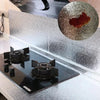 A kitchen countertop with a black induction cooktop and a silver textured backsplash liner.