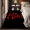 A black doormat with a red stylized logo is placed on a wooden floor in a modern interior setting.