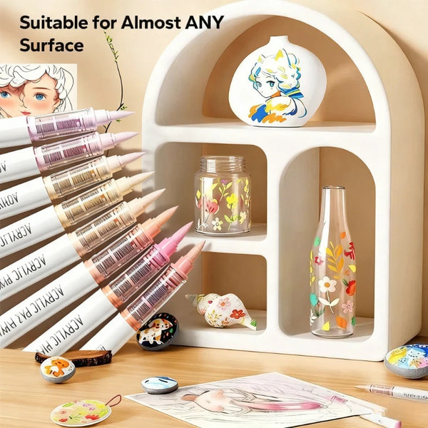 A white acrylic brush pen set is displayed on a shelf with various brushes and a decorative ceramic vase.